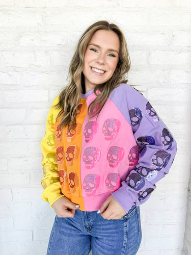Queen of Sparkles Colorblock Multi Skull Sweatshirt with color blocking stripes of yellow, orange, pink and light purple with sequin beaded skulls