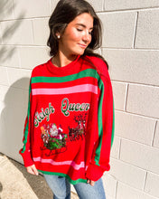 Load image into Gallery viewer, Model wearing Queen of Sparkles “Sleigh Queen” red stripe sweater with green/pink bands and sequin Santa sleigh